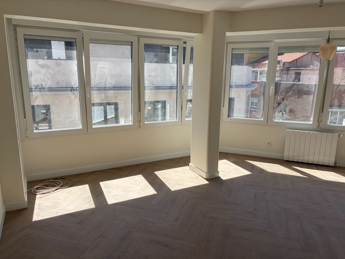 Salón terminado con suelo de espiga y ventanales al exterior