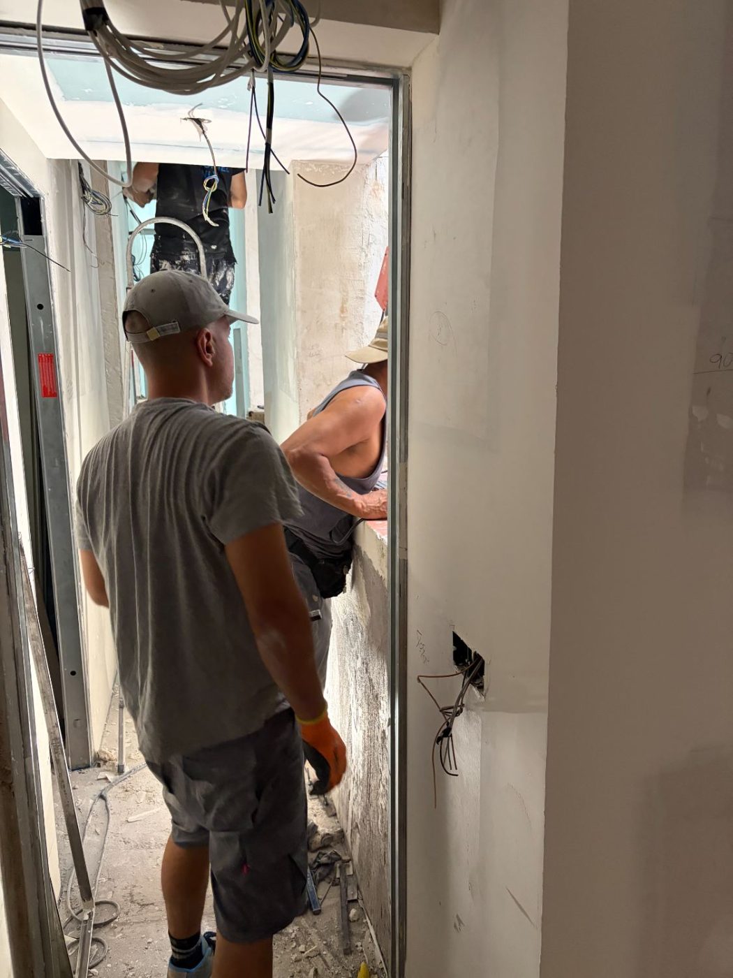 Dos oficios coordinándose en el pasillo durante la reforma
