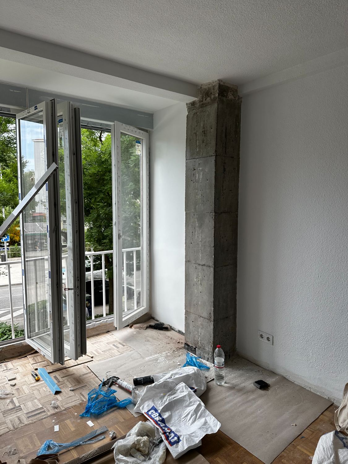 Ventana nueva instalada junto al pilar de hormigón durante la obra