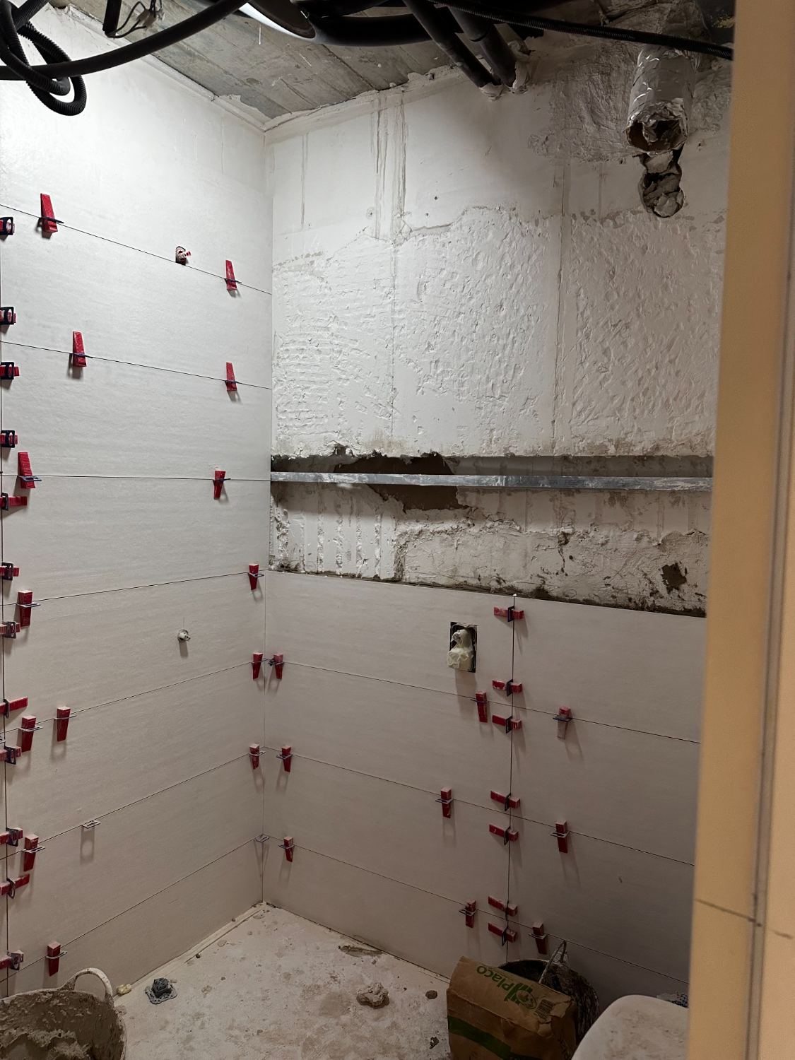 Alicatado de un baño en ejecución, con crucetas de nivelación