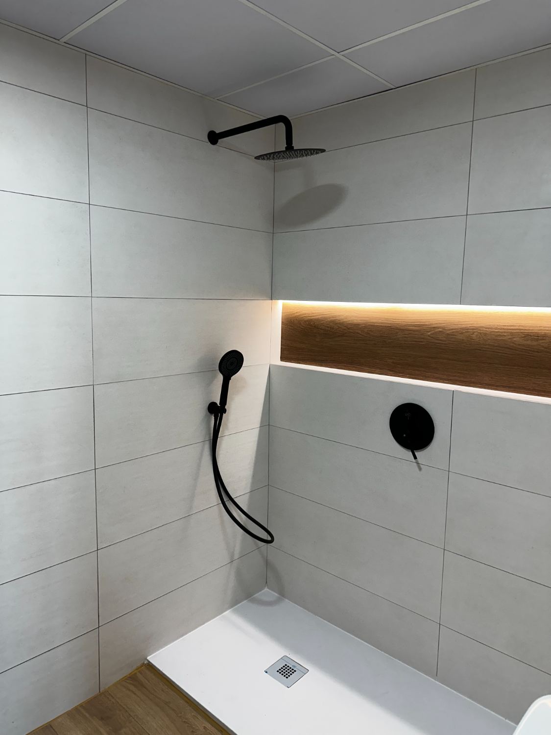 Ducha terminada con hornacina iluminada y grifería negra
