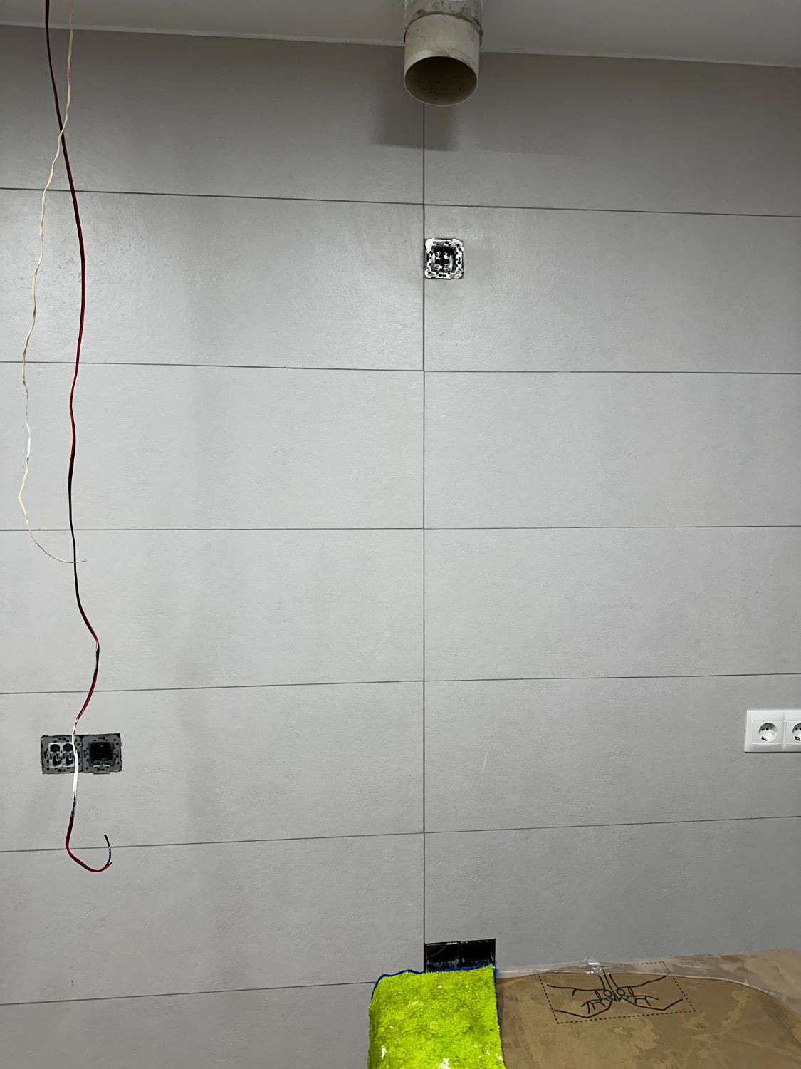 Mecanismos eléctricos sin embellecer sobre el alicatado terminado