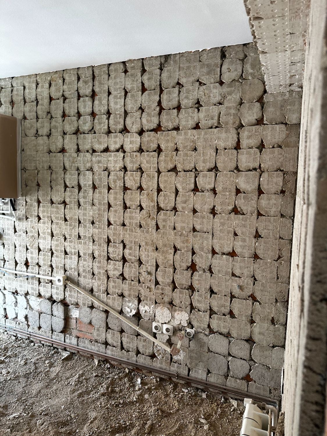 Muro picado hasta el ladrillo durante la demolición